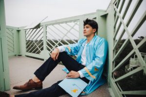 Graduate in Gown Sitting near Railing